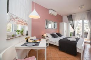 a bedroom with a bed and a table in a room at Apartmani Škopac Rabac in Rabac +13 photos
