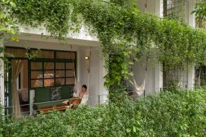 a woman sitting on the porch of a house at Big Tree Boutique Hotel in Ko Tao