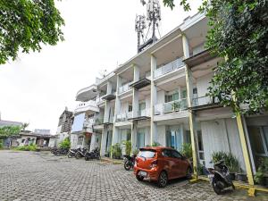 a red car parked in front of a building at OYO 90451 Hotel Roda Mas 1 in Purwokerto