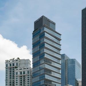 a tall glass building in front of some buildings at Capri by Fraser, Bukit Bintang in Kuala Lumpur