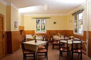 um restaurante com mesas e cadeiras num quarto em Chata Šumava em Hojsova Stráz