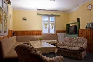 uma sala de estar com um sofá e duas cadeiras e uma mesa em Chata Šumava em Hojsova Stráz