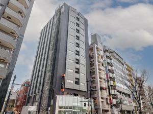 wysoki budynek na rogu ulicy miejskiej w obiekcie APA Hotel Kamata-Ekimae w Tokio