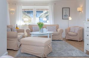 a living room with couches and a table and chairs at Haus Meerblick in List