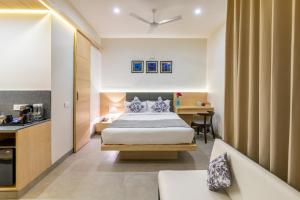 a hotel room with a bed and a kitchen at Iris Suites in Bangalore