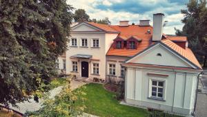 uma grande casa branca com um telhado laranja em Dwór Zbożenna em Przysucha