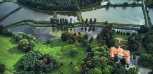 an aerial view of a house on a island in a lake at Dwór Zbożenna in Przysucha