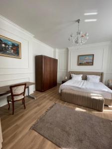 a bedroom with a bed and a table and a chandelier at FELIX KANITZ Apartments - in the heart of Kapana district in Plovdiv