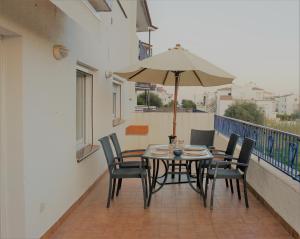 einen Tisch und Stühle mit Sonnenschirm auf dem Balkon in der Unterkunft Apartament amb terrassa i parking in Llança