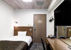 a bedroom with a bed and a desk and a tv at APA Hotel Kamata-Ekimae in Tokyo