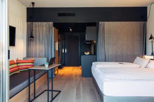 una camera d'albergo con letto e tavolo di harry's home hotel & apartments a Telfs