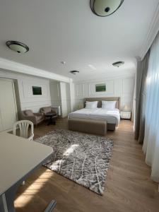 a bedroom with a bed and a table and a rug at FELIX KANITZ Apartments - in the heart of Kapana district in Plovdiv