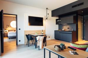 een keuken en een woonkamer met een tafel en stoelen bij harry's home hotel & apartments in Telfs