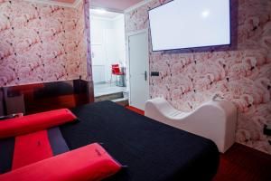um quarto com uma mesa e uma televisão na parede em Motel Venus Santiago em Santa María