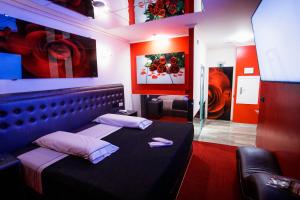 Una habitación con una cama en una habitación con pinturas en Motel Venus Santiago en Luou