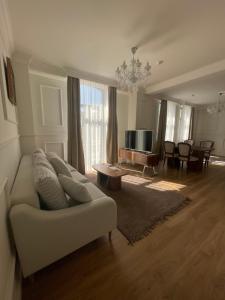 a living room with a white couch and a television at FELIX KANITZ Apartments - in the heart of Kapana district in Plovdiv