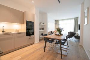 een keuken en een woonkamer met een houten tafel en een eetkamer bij Meerliebe in Norderney