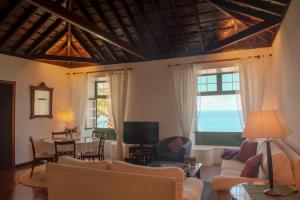 uma sala de estar com sofás, uma mesa e uma televisão em Alenes del Mar em San Juan de la Rambla