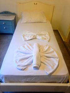 
a bed with white sheets and pillows on it at Sofia Rooms in Loutro
