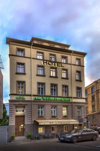 a hotel with a car parked in front of it at Hotel am Wilhelmsplatz in Stuttgart