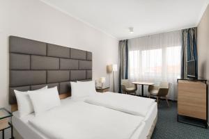 a hotel room with a large bed and a television at Danubius Hotel Raba in Győr