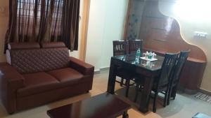 班加羅爾的住宿－THE NISARGA GRAND，客厅配有沙发和桌子