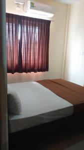 1 dormitorio con 1 cama y una ventana con en THE NISARGA GRAND en Bangalore