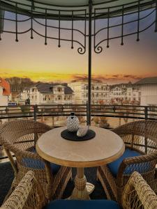 a table and chairs on a balcony with a view at Hotel Glückauf 1908 in Ostseebad Sellin