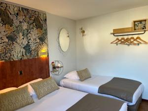 Zimmer mit 2 Betten und Wandgemälde in der Unterkunft Hotel Arc-En-Ciel Colmar Contact Hotel in Colmar