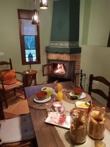 
a living room with a table and a fire place at Hotel Cortijo de Salia in Alcaucín
