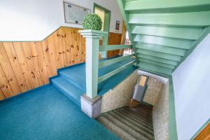 uma escada numa casa com pisos azuis e uma planta em Chata Šumava em Hojsova Stráz