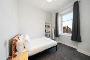 a small bedroom with a bed and a window at Ferry Gem in Broughty Ferry