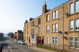 a street with buildings and cars parked on the street at Ferry Gem in Broughty Ferry