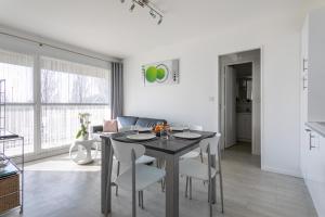 a kitchen and dining room with a table and chairs at Le P'tit Idéal in Cabourg