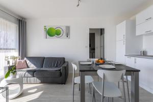 a kitchen and living room with a table and chairs at Le P'tit Idéal in Cabourg