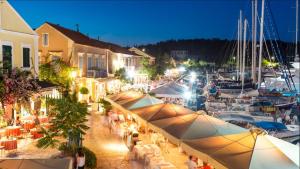 a group of people sitting at tables at a marina at night at Fiscardonna Luxury Suites in Fiskardo