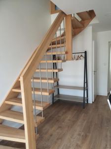 a wooden staircase in a living room with wooden floors at le vergoyer in Calais