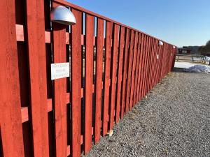 a red fence with a sign on it at Rekasta Bed & Breakfast in Enköping