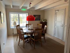 a dining room with a table and chairs and a red lamp at Rekasta Bed & Breakfast in Enköping