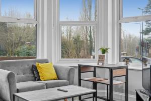 sala de estar con sofá, mesa y ventanas en BridgeCity Luxurious Holiday Apartment Maidstone - f1 en Kent