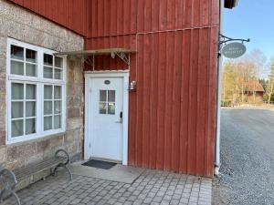 a red building with a white door and a bench at Rekasta Bed & Breakfast in Enköping