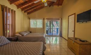 羅阿坦的住宿－Relaxing Tropical Cabin，一间卧室配有两张床和一台平面电视