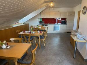 ein Zimmer mit Tischen und Stühlen sowie einer Küche in der Unterkunft Landhaus Monika in Meckenbeuren
