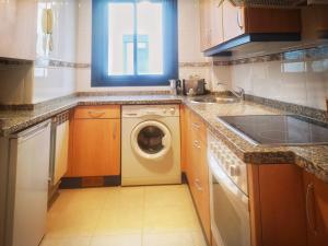 a kitchen with a washing machine and a window at CLOIS, luanco centro in Luanco