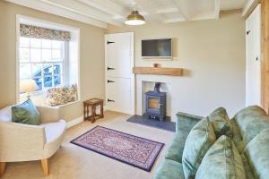 Host & Stay - Holmlea Cottage في Lockton: غرفة معيشة مع أريكة ومدفأة