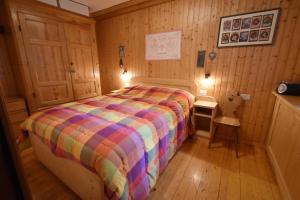 - une chambre avec un lit dans une pièce en bois dans l'établissement Masetto Pramagnan, à Madonna di Campiglio