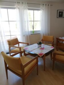 ユーバーリンゲンにあるFerienwohnung am Bodensee mit 3 Schlafzimmer über 2 Etage mit kleine Balkon bis 7 Personenのリビングルーム(テーブル、椅子、窓付)