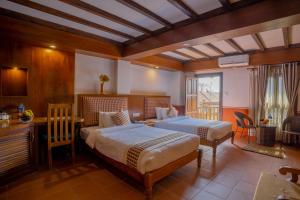 una camera d'albergo con 2 letti, scrivania di Pahan Chhen - Boutique Hotel a Kathmandu