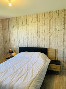 um quarto com uma cama grande e uma parede de madeira em Tenat Er Vorc'h, Grande maison neuve, Wifi, Erdeven em Erdeven