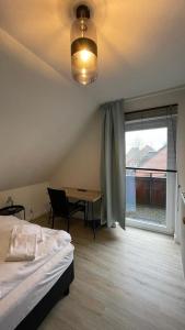 una camera con letto, tavolo e finestra di Gästehaus Ivonne a Lohe-Rickelshof
